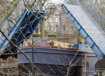 barge-coming-under-blue-bridge.jpg