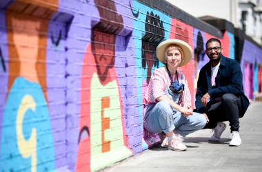 Two people in front a new painted mural.